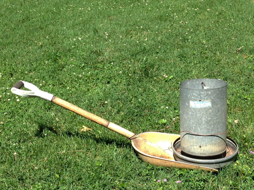 Put the metal feeder on the blade of a large, wide shovel